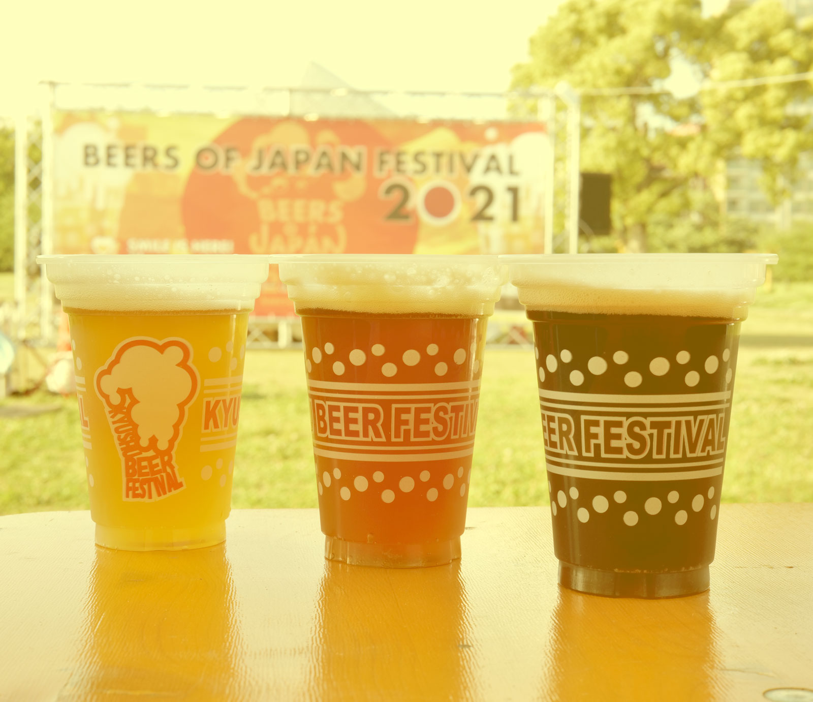ビアーズオブジャパンフェスティバルのオリジナルプラカップに注がれた3種類のクラフトビールがテーブルに置かれた屋外の写真