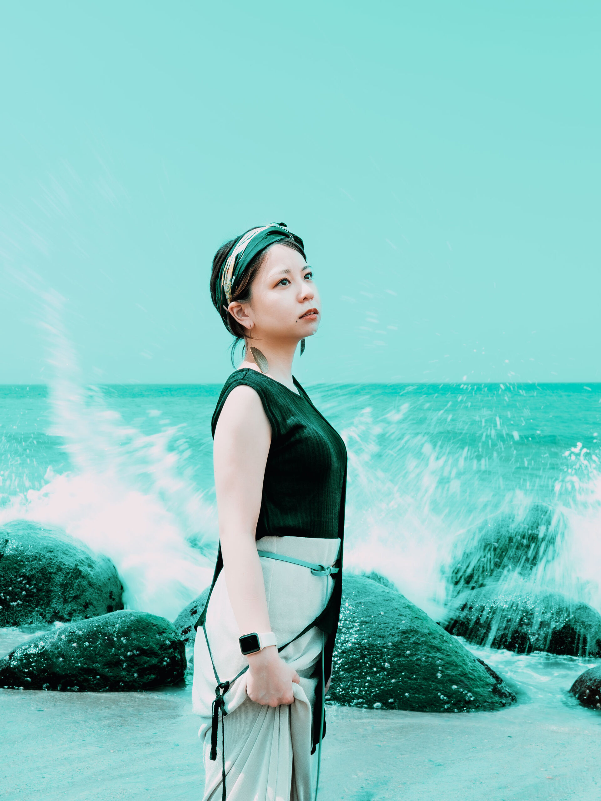 福岡県糸島市二見ヶ浦の海辺で撮影したポートレートモデルSerinaさんの写真　彼女の背には波が岩に砕けて鮮やかに飛び散っています