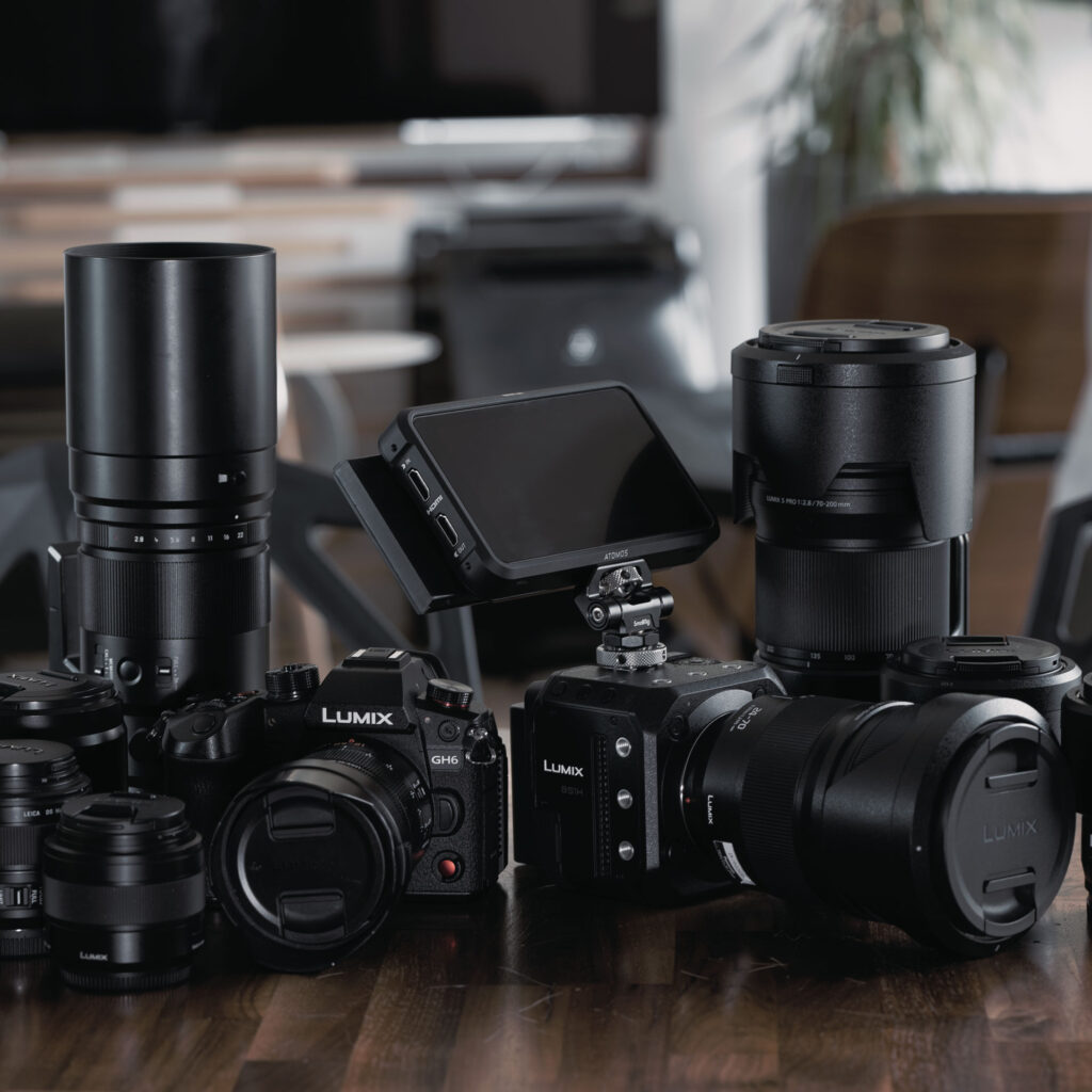 テーブルの上に無造作に並べられた沢山のLUMIXシリーズのカメラボディやレンズ