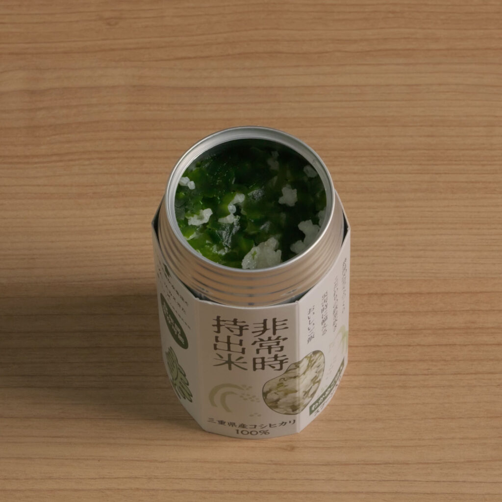 缶を開けて青菜を混ぜたご飯を見せた「非常時持出米時」の商品